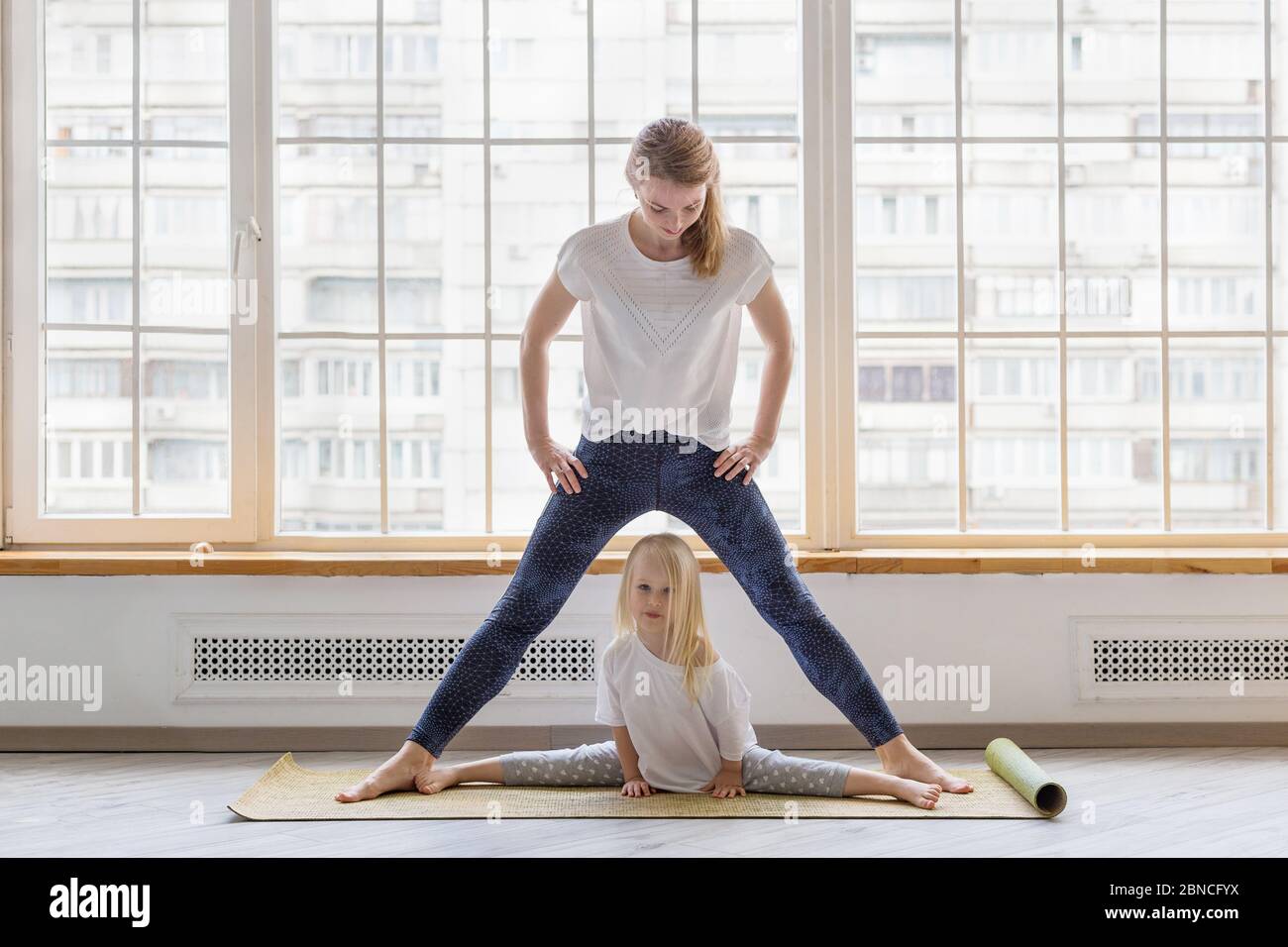 Young mother doing stretching exercises with her daughter Stock Photo