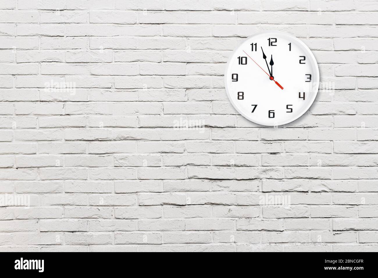 White wall clock on white brick wall background Stock Photo Alamy
