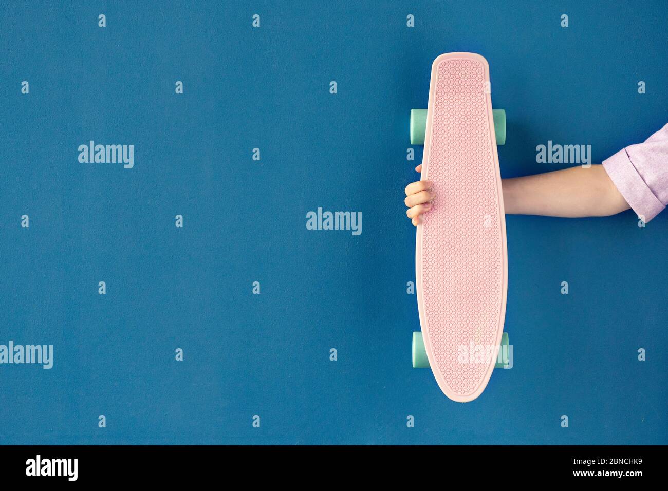 Female hand holding plastic skateboard cruiser deck Stock Photo