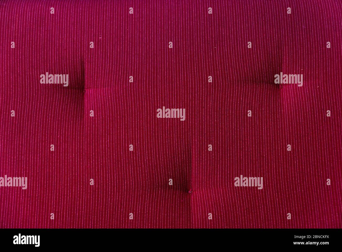 A fragment of the upholstery of the sofa of red color close up Stock Photo