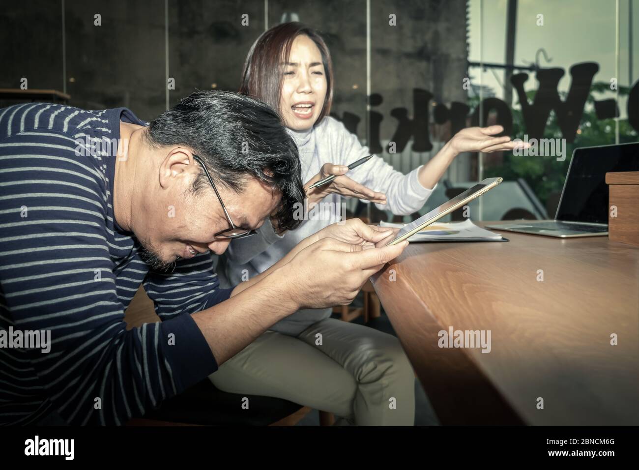 Happy young generation of Asian businessman and businesswoman are discussing work together in the modern office place with laptop and  tablet, smartph Stock Photo