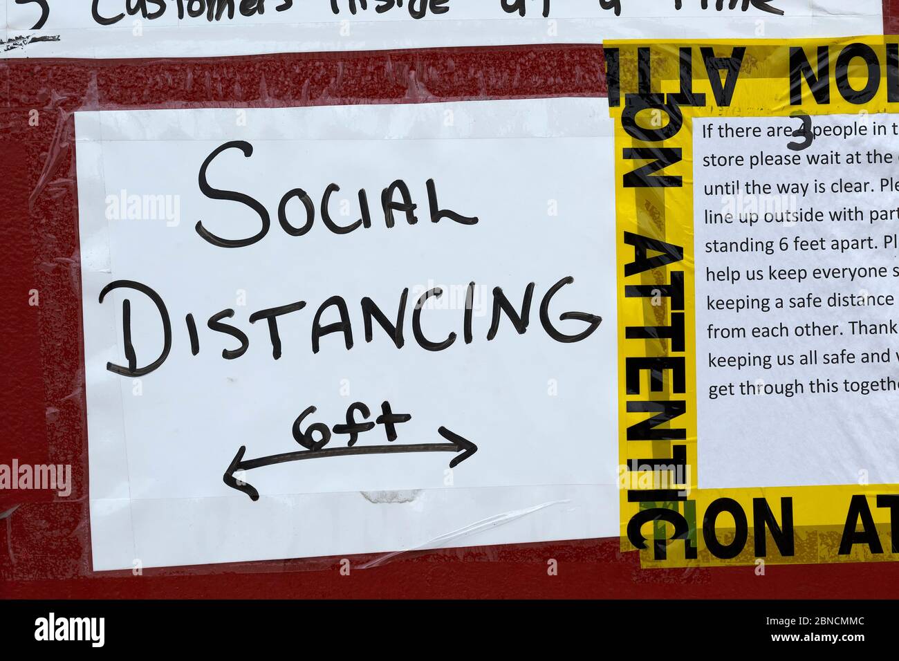 Hand made social distancing sign in business entrance due to COVID-19. Stock Photo