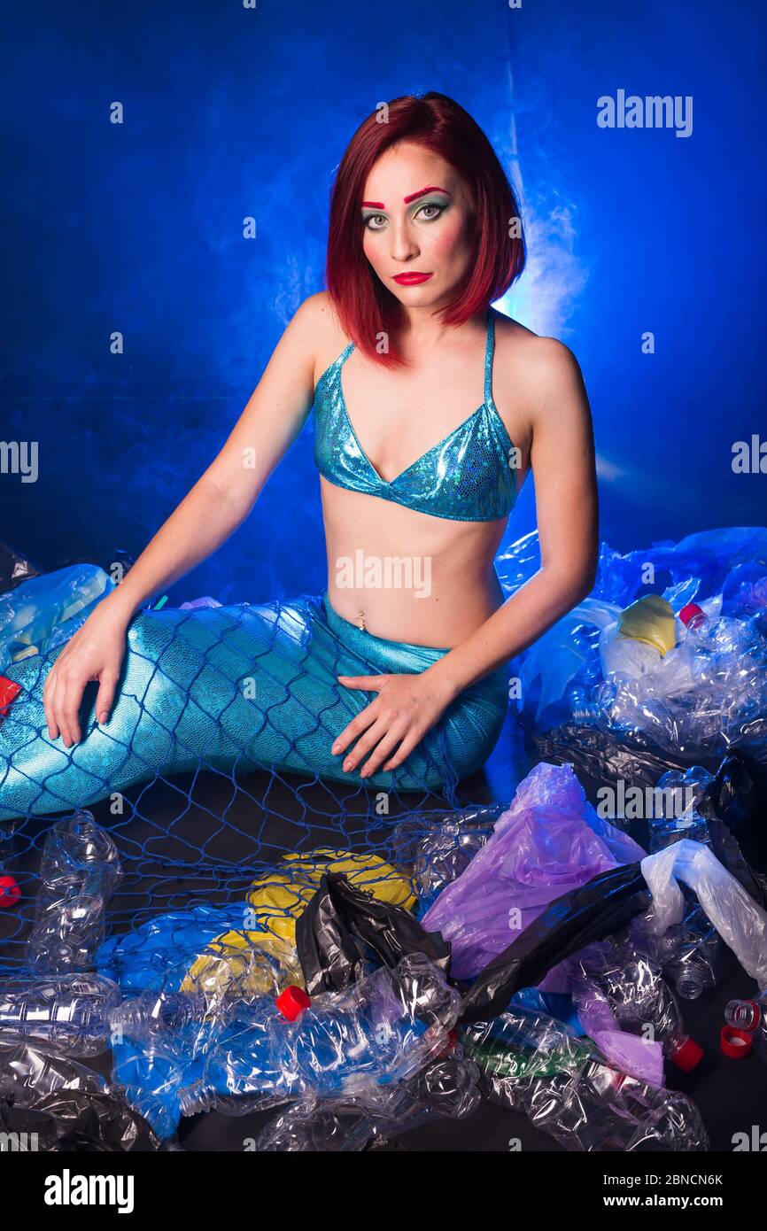 Fantasy mermaid in deep ocean shocked because water pollution