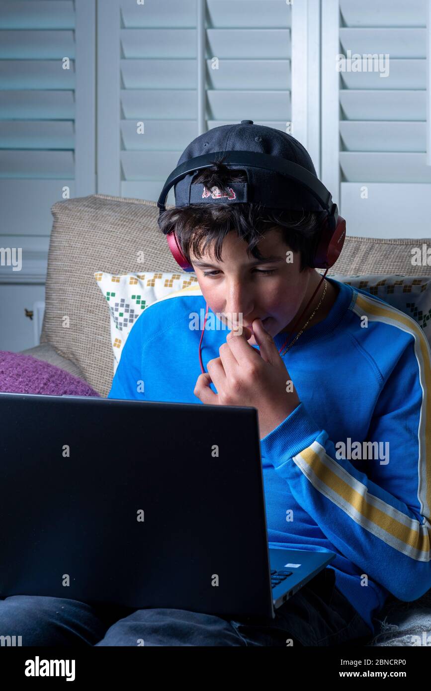 Teenage by, 13, watches movie online on laptop computer Stock Photo