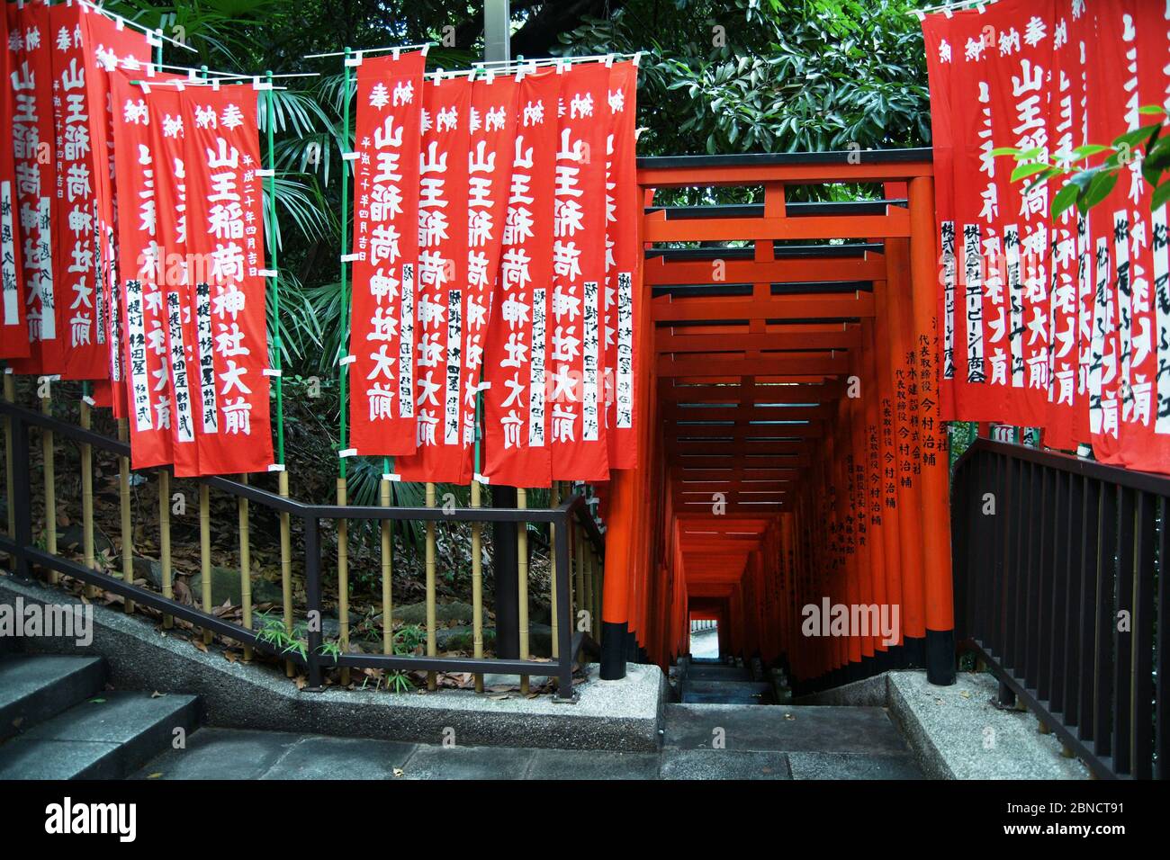 Eingang eines Tunnels aus roten Torii zu einem Shintō-Schrein im Zentrum von Tokio Stock Photo
