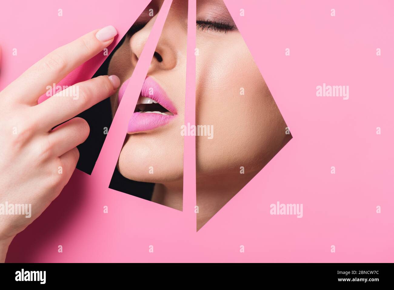 Woman with open mouth, closed eyes and pink lips across holes touching ...