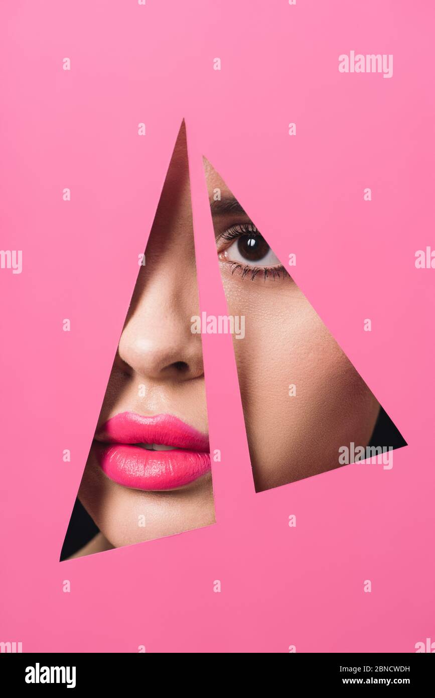 Female face with pink lips across triangular holes in paper Stock Photo ...