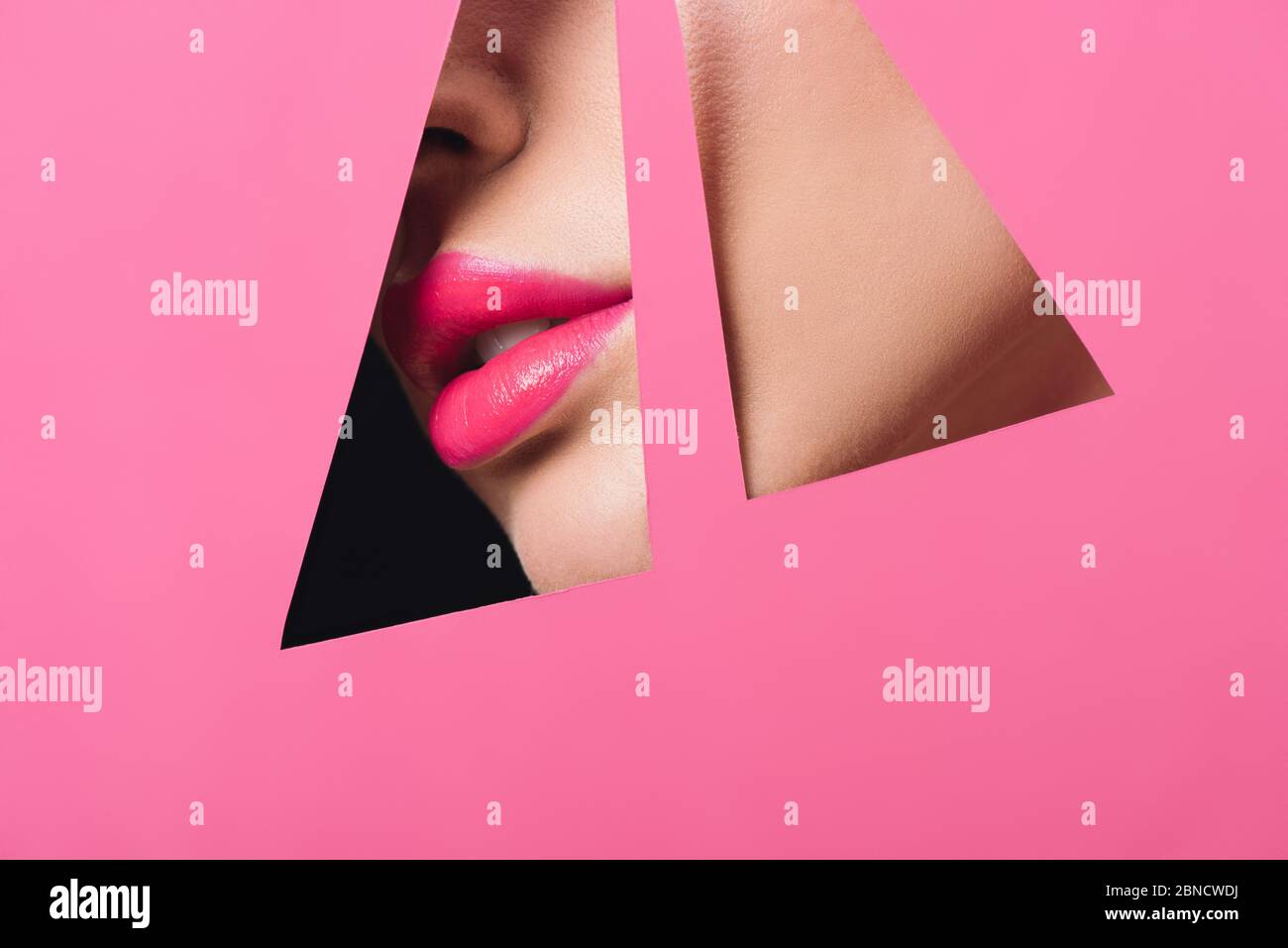 Cropped view of female face with pink lips across triangular holes in ...