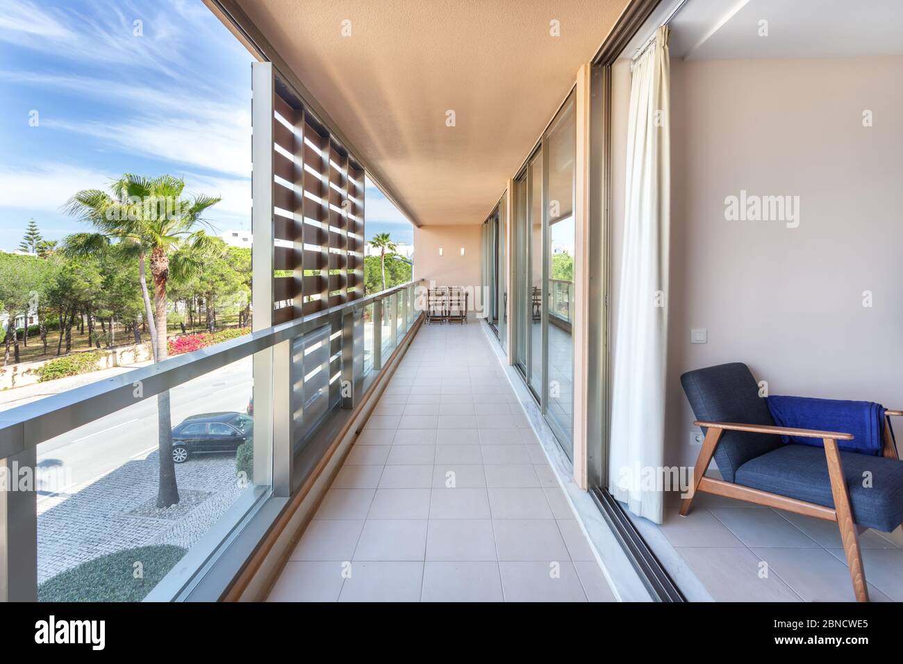 A modern, long corridor located outside the house, hotel, overlooking the street. Stock Photo