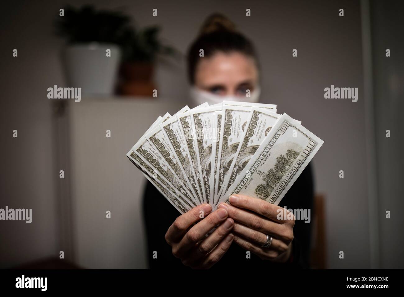 Single woman counting money bills during coronavirus time. Stock Photo