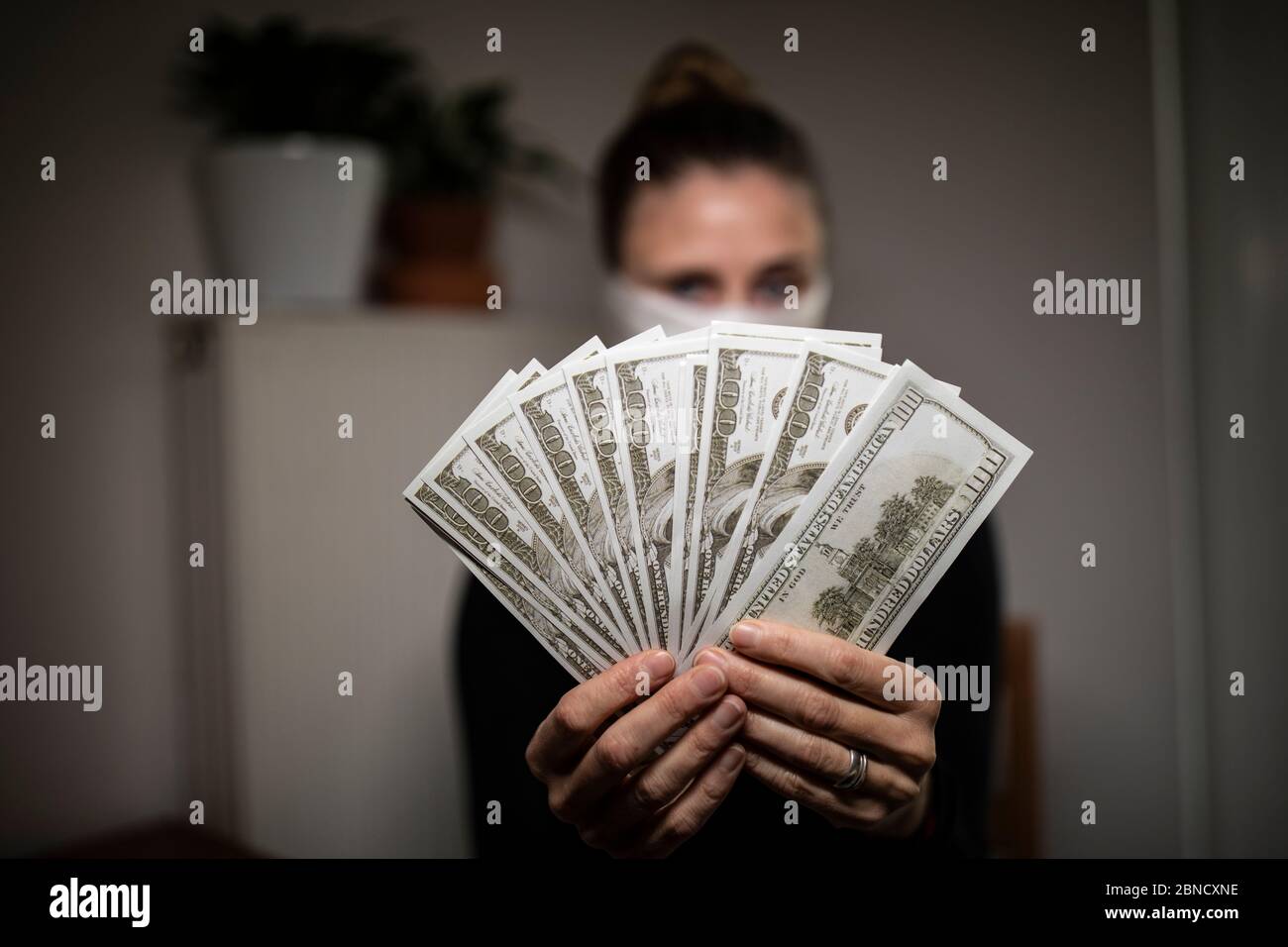 Single woman counting money bills during coronavirus time Stock Photo