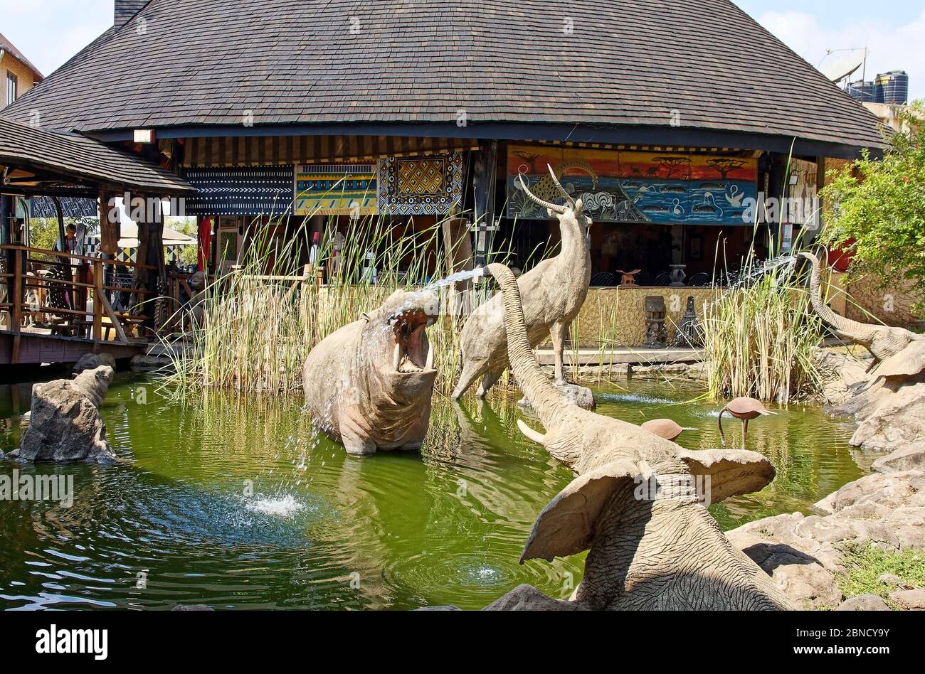 water garden, wild animal sculptures, two elephants spouting water, circular pavilion, shingle roof, Cultural Heritage Center, Africa, Arusha, Tanzani Stock Photo
