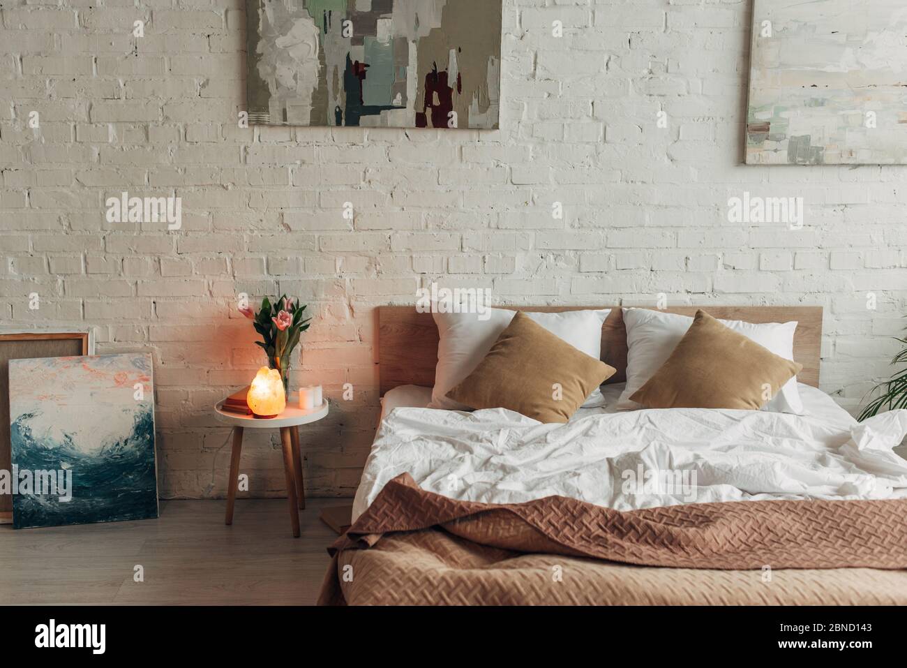 interior of bedroom with bed Himalayan salt lamp tulips and
