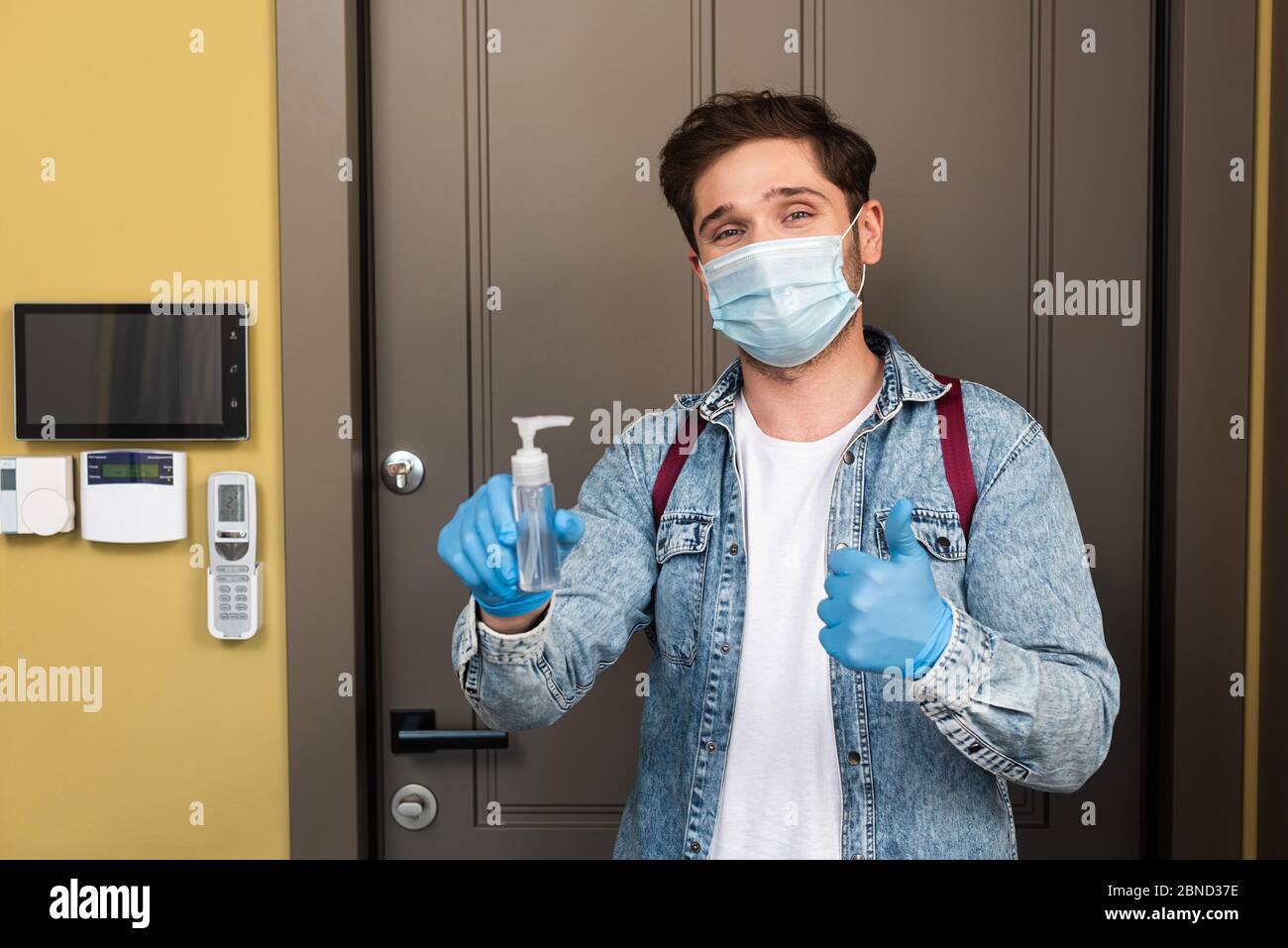 Delivery man wearing prevention mask and gloves is holding stack