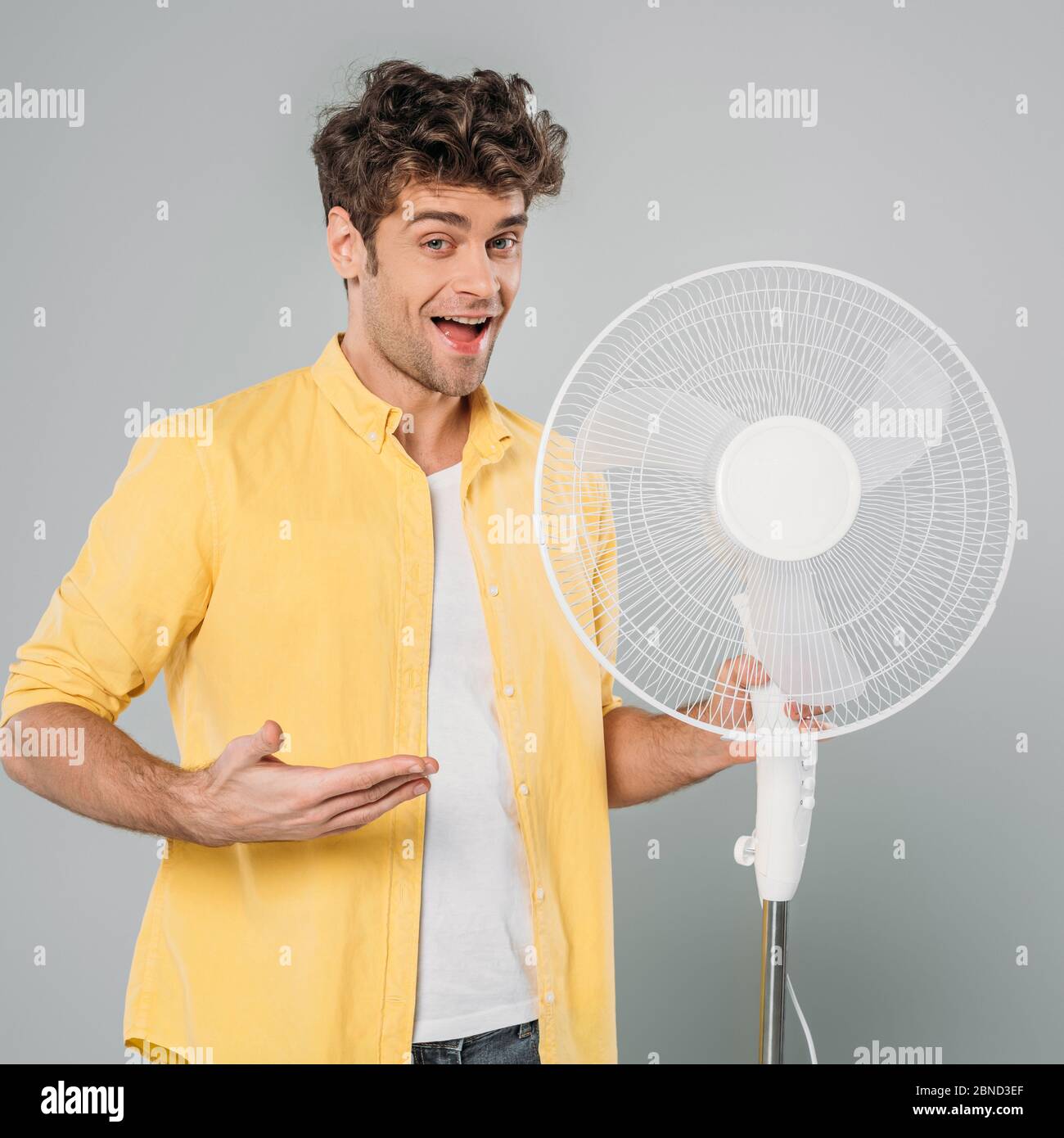 Excited man with open mouth looking at camera and pointing at electric ...