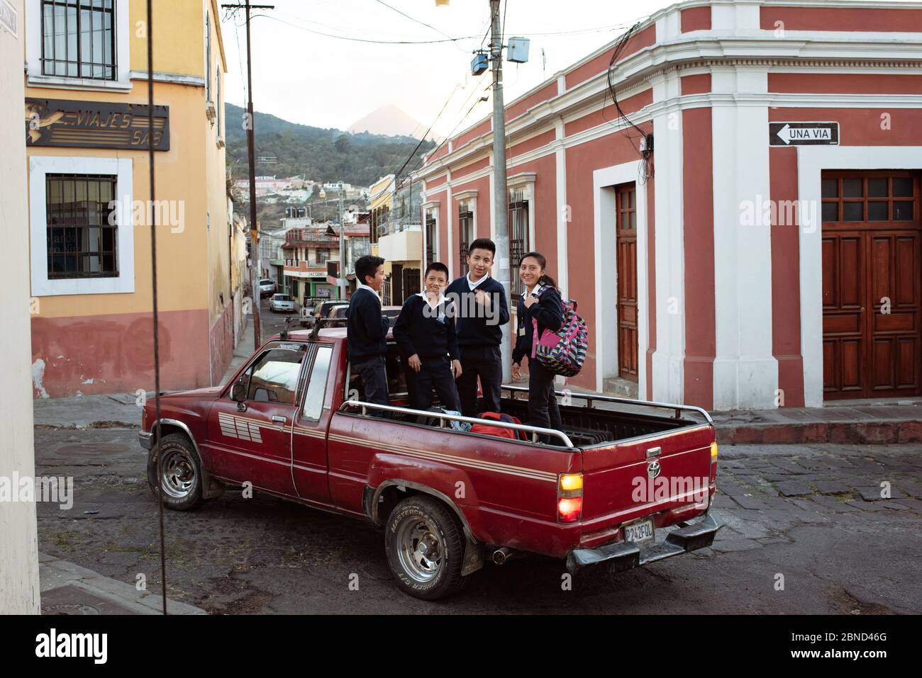 Happy school children getting a ride home in the back of a pick-up truck. Daily living in Quetzaltenango, Guatemala. Mar 2019 Stock Photo