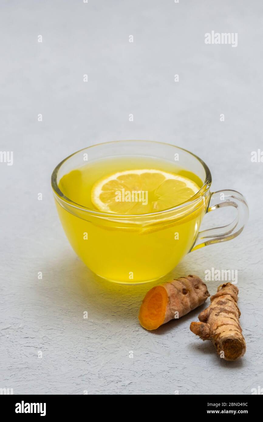 Ginger turmeric lemon detox tea on neutral background with copy space