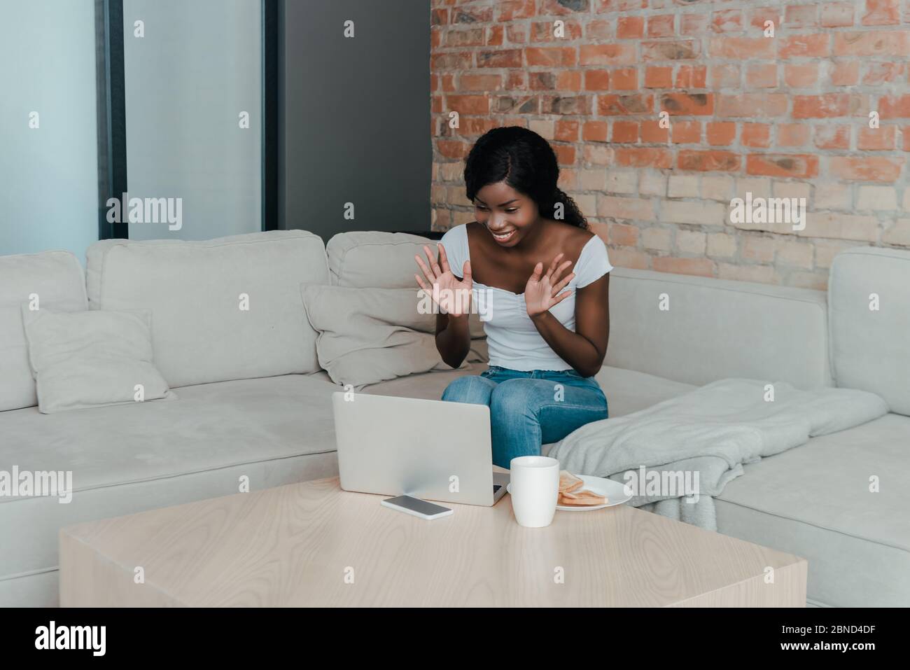 Happy african american freelancer having video call near coffee table ...