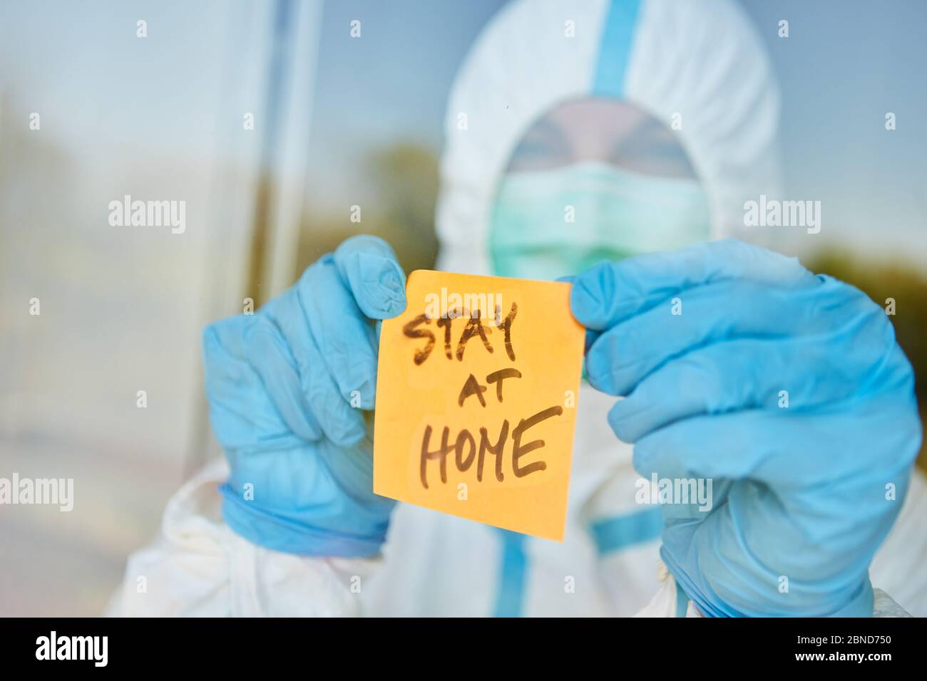 Stay at Home message on sticky note on door of clinic for coronavirus and Covid-19 pandemic Stock Photo
