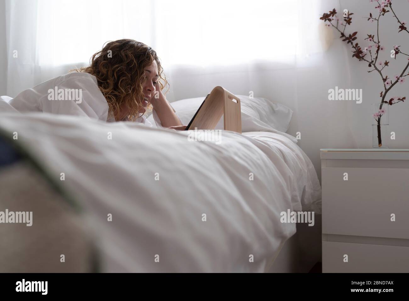 Young woman lying on a bed of flowers hi-res stock photography and ...
