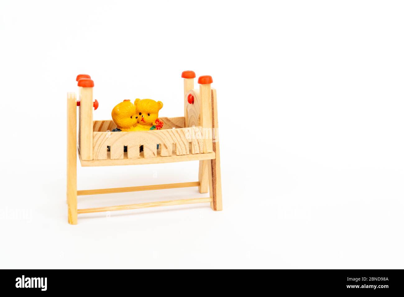 Toy teddy bears sit toy beds. Toy wooden bed. Wooden toy bed with a