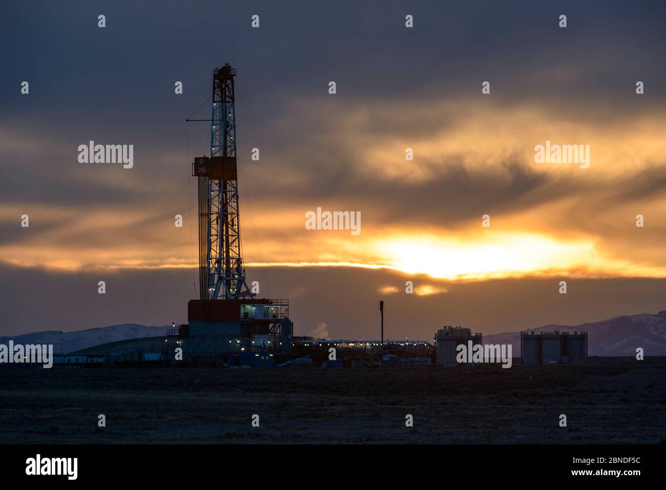 Natural gas drilling rigs on Pinedale Mesa at sunset, Sublette County, Wyoming, USA. May. Stock Photo