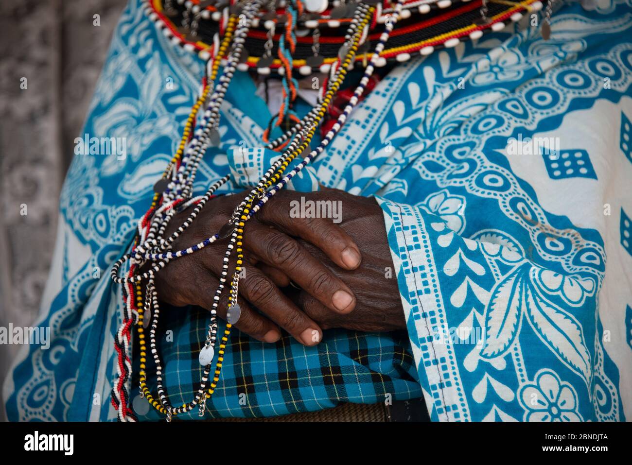 Maasai woman's hands in traditional clothing Stock Photo