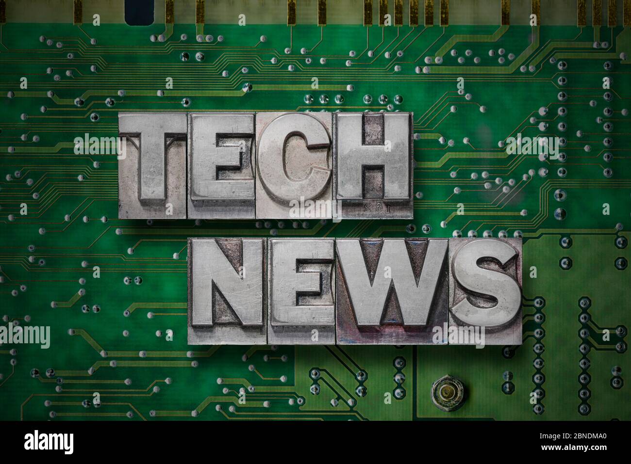 tech news phrase made from metallic letterpress blocks on the pc board ...