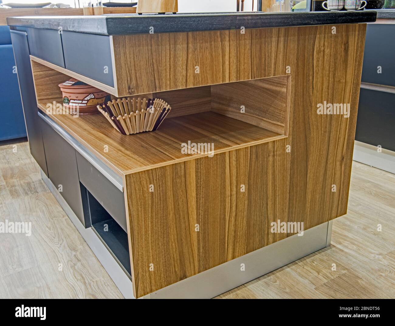 Interior Design Decor Showing Modern Kitchen Island With Wooden Shelf In Luxury Apartment Showroom 2BNDT56 