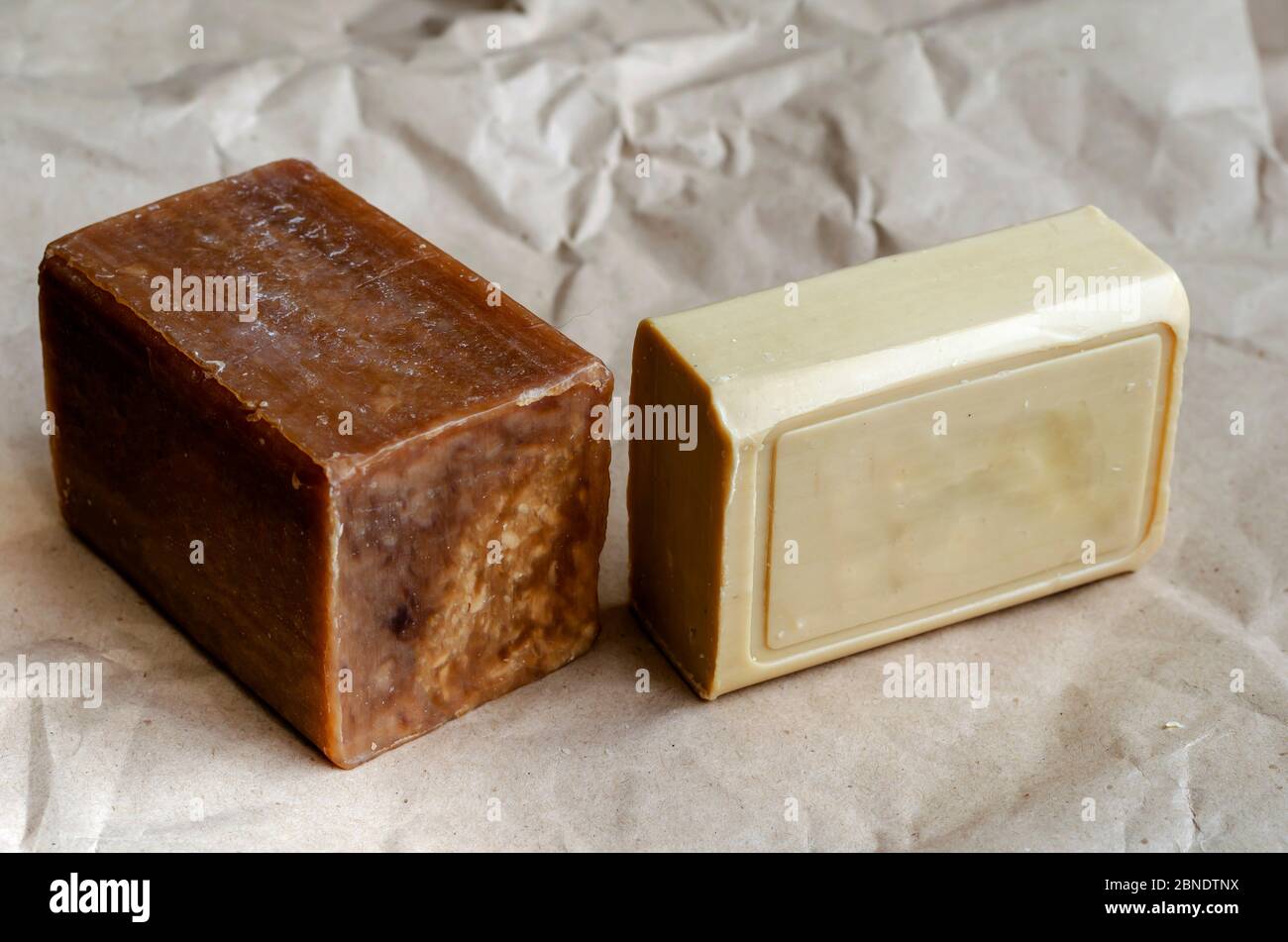 Various pieces of laundry soap on a plain background. Two rectangular pieces of new soap. Natural hygiene products. Place for text. Selective focus. Stock Photo