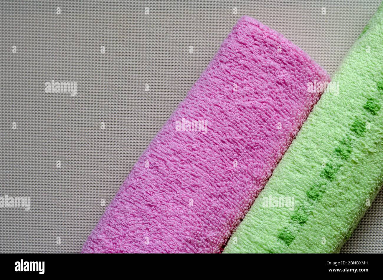 Soft multi-colored towels on a white textured background. Colorful bath towels. Health and hygiene care. View from above. Place for text. Stock Photo