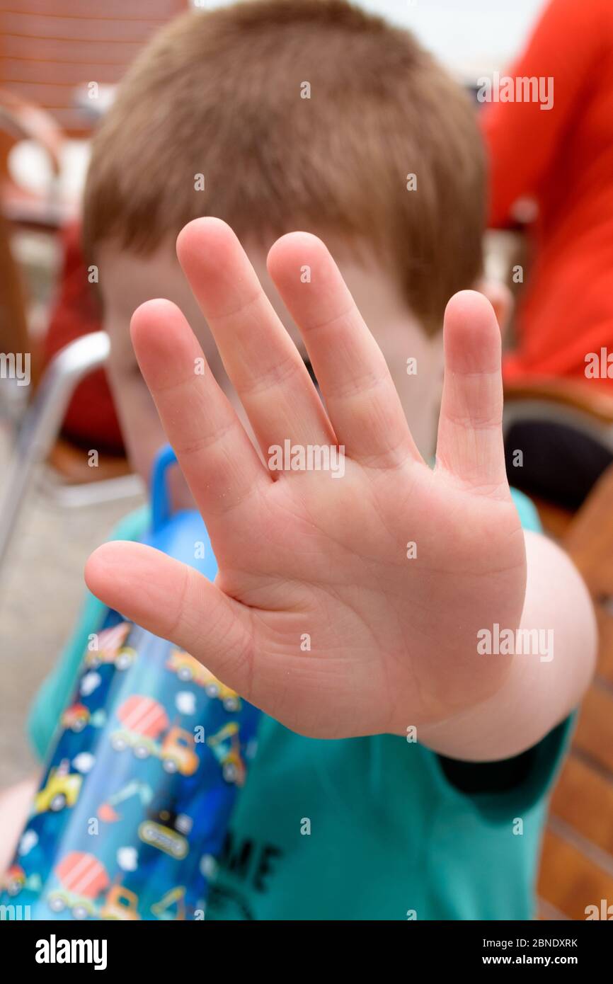 Concept of saying stop: small child holding up the palm of his hand in a gesture to say 'No' Stock Photo