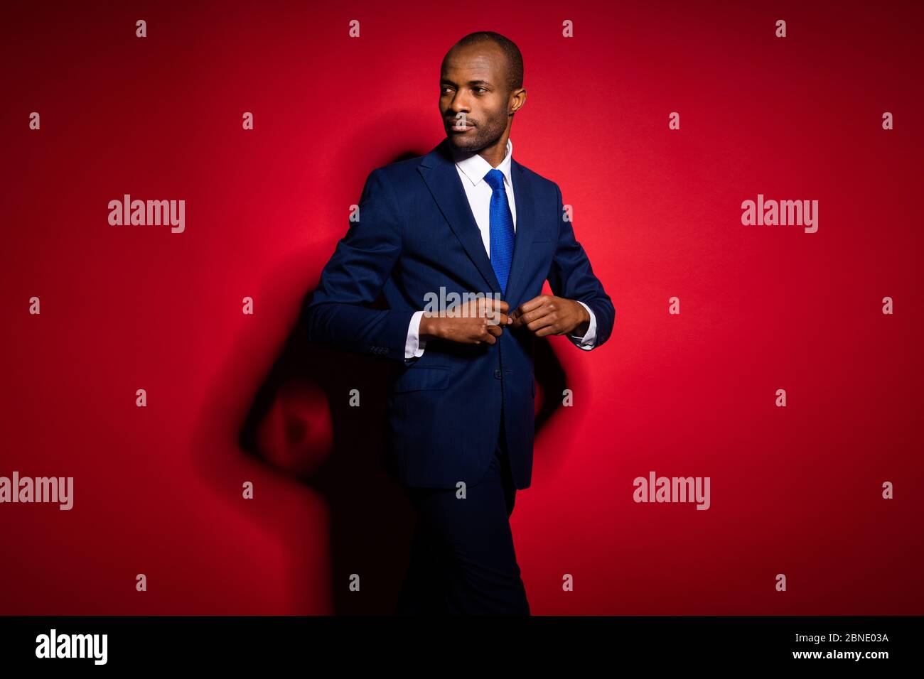 Portrait Of A Stylish Male In A Black Suit And Red Tie Isolated On