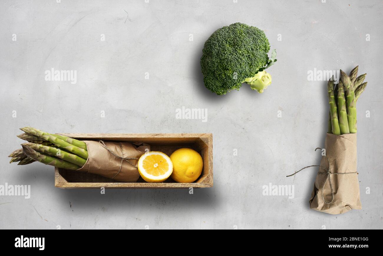asparagus, broccoli and lemon on a white chalk background Stock Photo