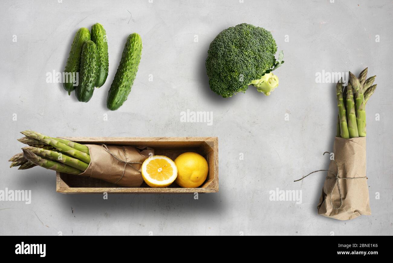 cucumber, asparagus, broccoli and lemon on a white chalk background Stock Photo