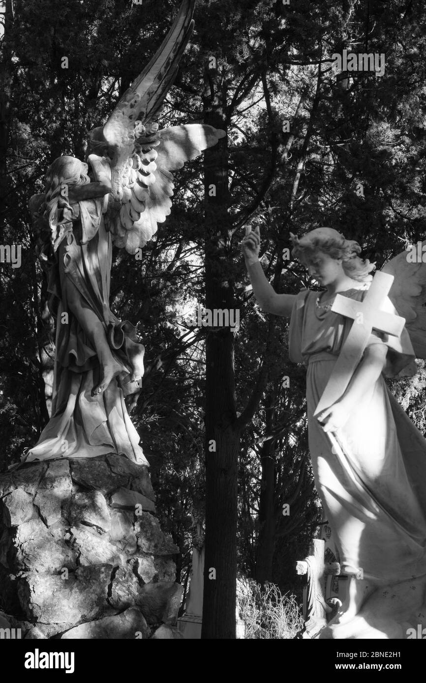 Grayscale vertical shot of an old statue in Montjuic Cemetery, Barcelona, Spain Stock Photo