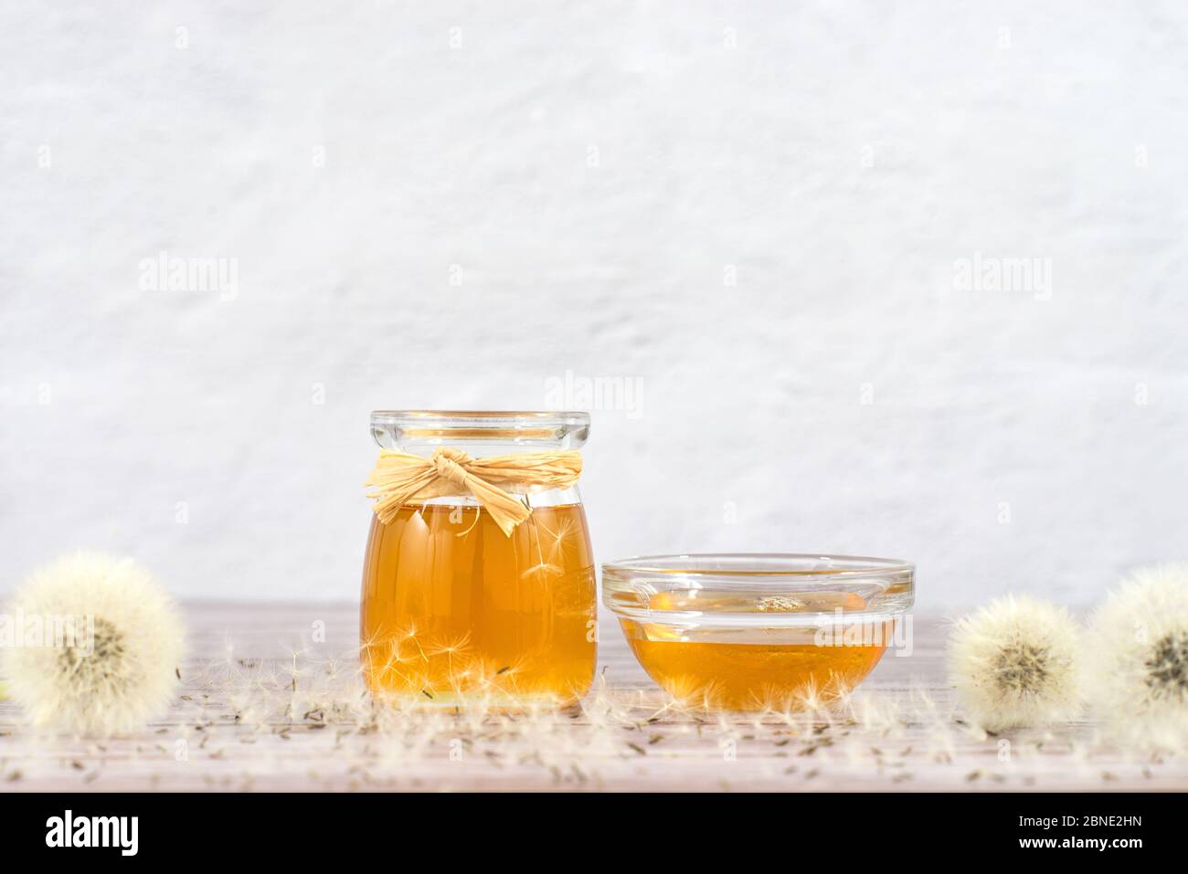 Dandelion jam, honey, jelly in a glass jar on a wooden table, white ...