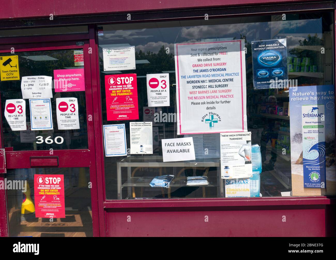 Chemist shop with multiple signage, posters, advising customers about accessing Covid-19 help. Stock Photo