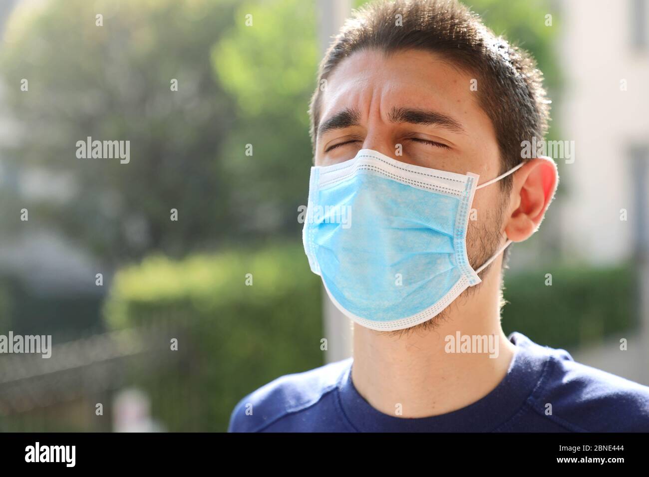 COVID-19 Pandemic Coronavirus Close up of man with surgical mask breathing outdoor Stock Photo