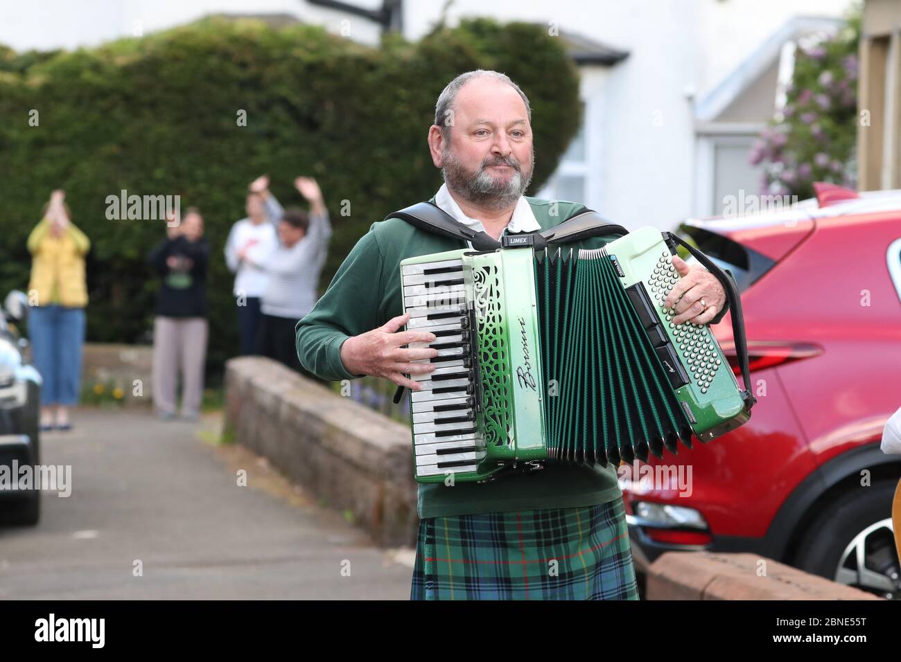 Seamus osullivan playing his accordion in his street in glasgow hires stock photography and