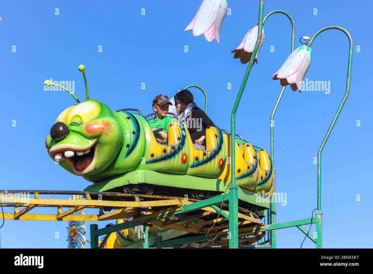 Caterpillar themed roller coaster for smaller children in travelling funfair  or carnival Stock Photo