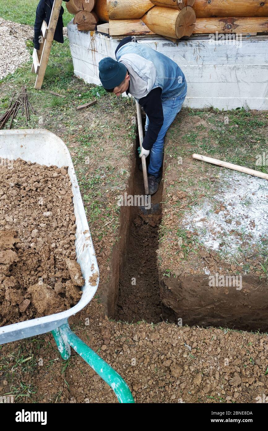 A worker digs a trench shovel near the house.2020 Stock Photo Alamy
