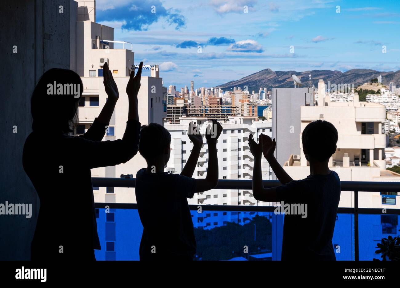 Applause to medical staff. Family clapping hands, applauding from balcony to support doctors, nurses, hospital workers Stock Photo