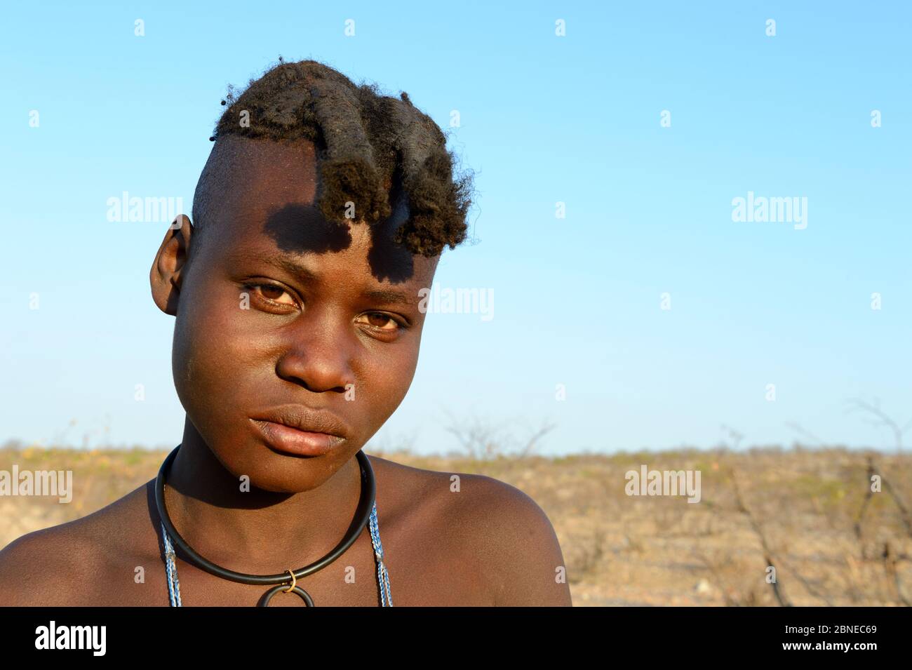 Portrait of Himba girl with the typical double plait hairstyle of the pre-adolescent. Kaokoland, Namibia. October 2015 Stock Photo