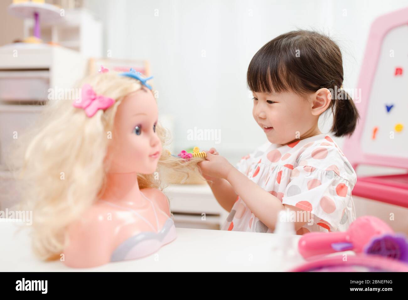 toddler girl pretend play as hairdresser at home Stock Photo Alamy