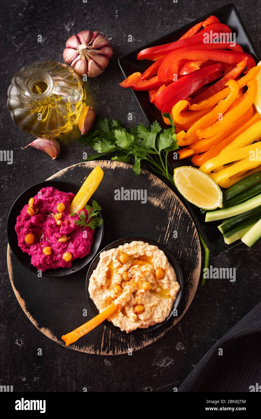 Top view of assorted fresh vegetables platter with various hummus dips Stock Photo