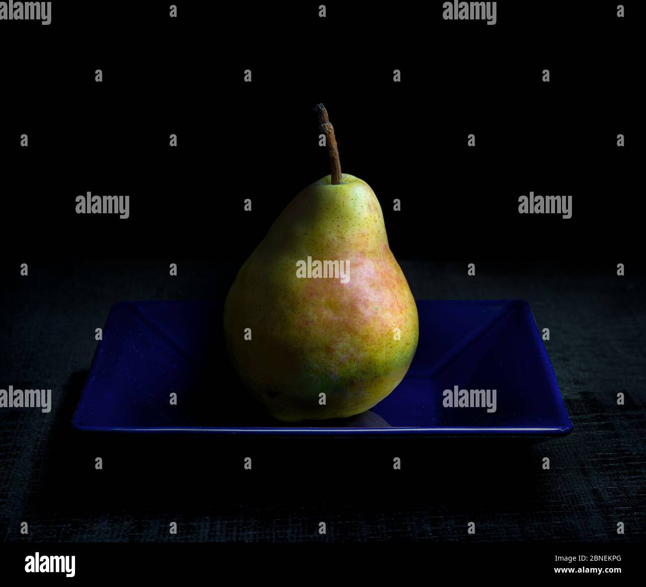 Bartlett pear on blue plate. Stock Photo