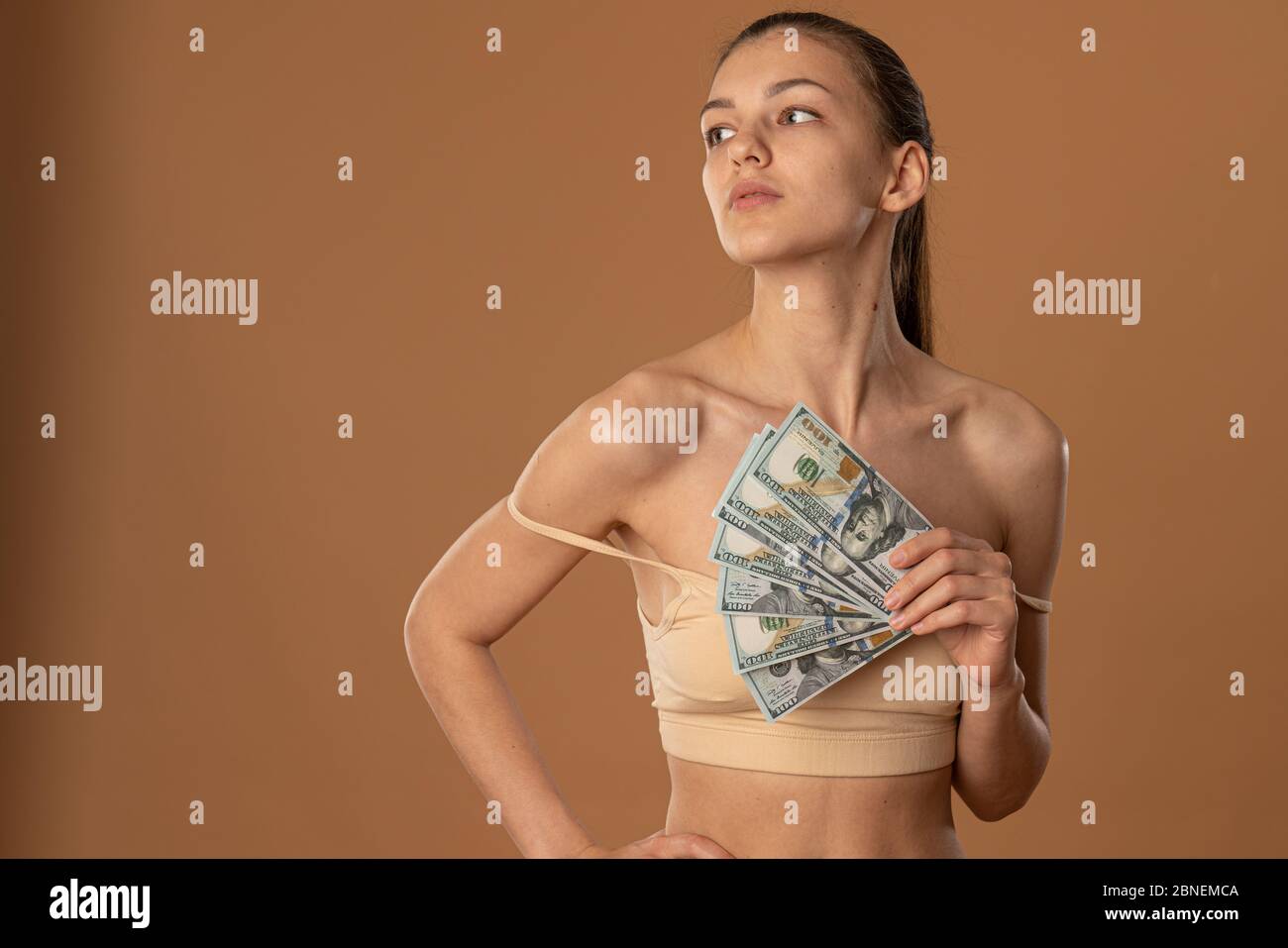 Woman's arm holding a beige bra Stock Photo