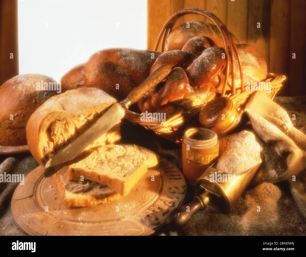 Selection of breads, breadboard and flour, Winkfield, Berkshire, England, United Kingdom Stock Photo