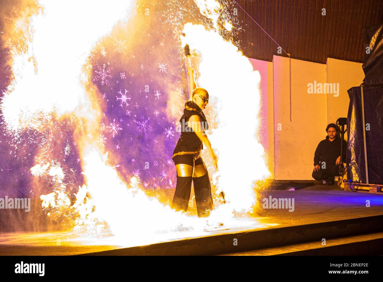 Amazing view of fire performer standing on a stage Stock Photo